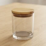 Pote de vidrio transparente con tapa de bamboo y sello para vela